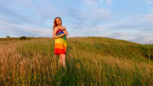 Femme lesbienne avec drapeau LGBT sur un champ vert — Photo
