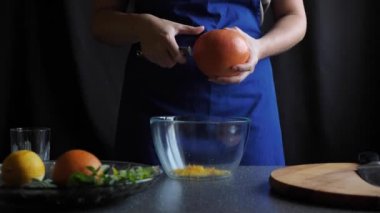 Kadın greyfurt kabuğunu çıkarıyor.