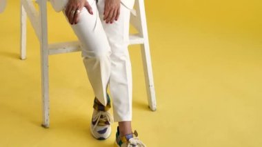 Beyaz takım elbiseli iş kadını gülümsüyor.