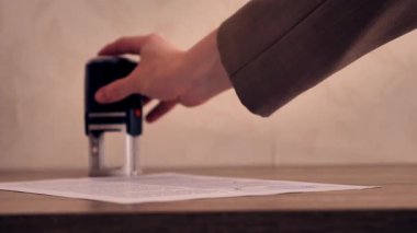 Beyaz kağıt bir belgeye siyah kendi kendine basan bir kauçuk damga ya da ahşap bir masanın üzerinde duran bir kontrat.