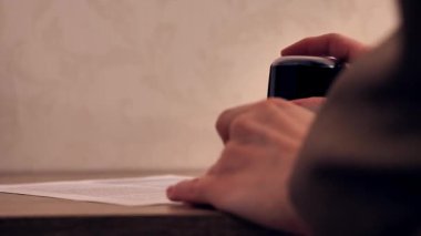 Kağıt üzerinde pul ve damga kullanan kadın el, yakın plan.