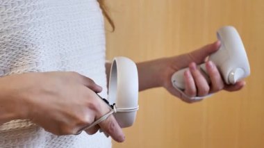 Sanal dünyada oyun ve navigasyon için kullanılan beyaz, kablosuz VR kontrolörleri tutan insanların yakın çekimleri. Odaklandığımız nokta aksiyon ve teknoloji.