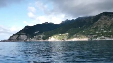 İtalya 'nın Amalfi Sahili' ndeki Positano kasabasının muhteşem manzarası. Sarp kayalıklara, yemyeşil tepelere Akdeniz bitkilerine, mavi Tyrhenian Denizi 'nde yüzen tekne ve yatlara inşa edilmiş beyaz evler..