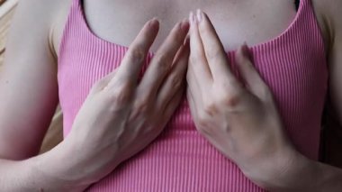 Pembe bluzlu bir kadın göğüs muayenesi yapıyor. Mammografi, onkoloji önleme ve erken kanser teşhisi konsepti.