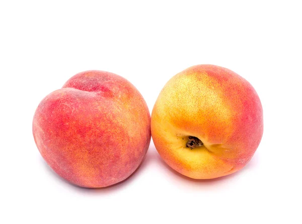 Два ярких сочных персика на белом фоне — стоковое фото