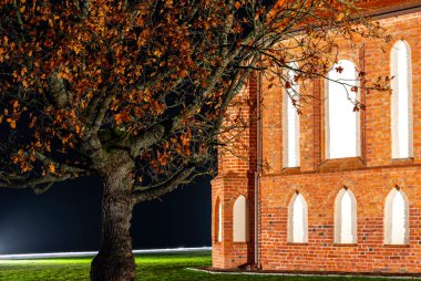 Geceleri beyaz boş pencereli antik kırmızı tuğla bina..