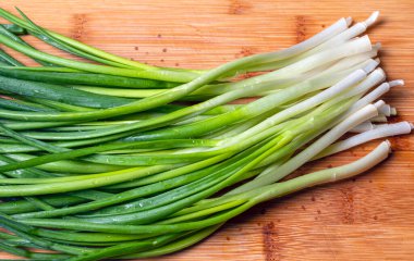 Ahşap zemin üzerinde yeşil taze soğan manzarası.