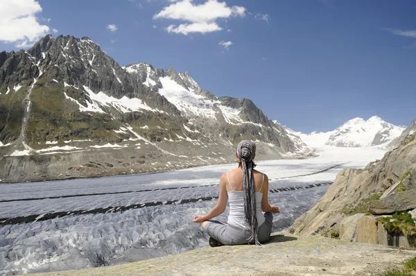 Girl in yoga position above the glacier — Stock Photo, Image