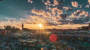 Yamaa el Fna Meydanı, pazarları, kalabalığı ve arka plandaki cami kulesi, gün batımında. Seyahat konsepti. Marakeş, Fas
