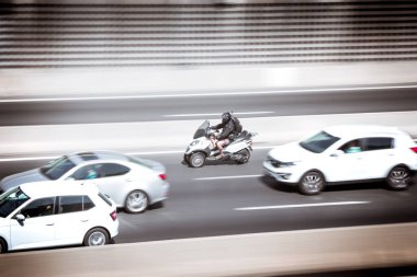 Tur arabası ve motosiklet şehirde hızla süpürülüyor. Ulaşım kavramı.