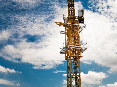 İnşaat sitesinde mavi gökyüzünün altında boş bir vinç