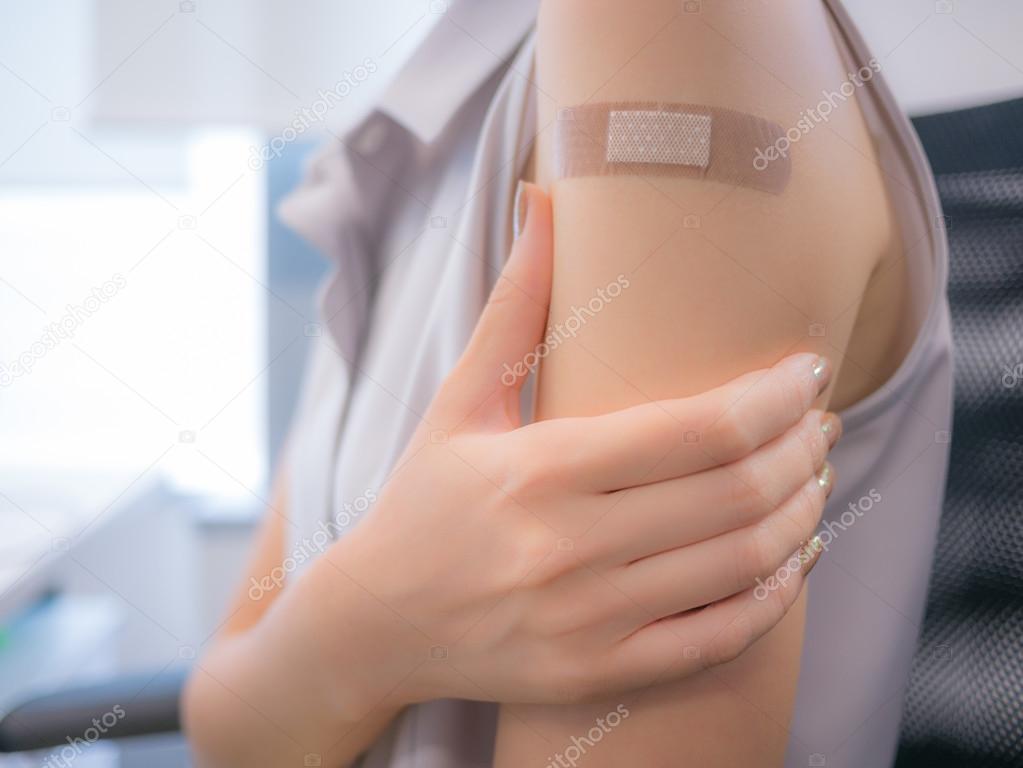 Adhesive bandage on a female arm after vaccination