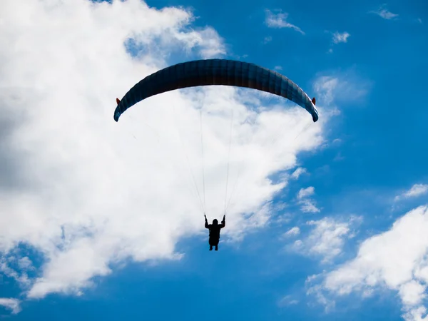 Silhueta de parapente com céu azul e nuvens brancas — Fotografia de Stock