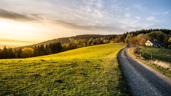 Podzimní krajina a venkovská cesta při západu slunce — Stock fotografie