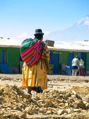 Bolivian cholita walking on the street of El Alto clipart