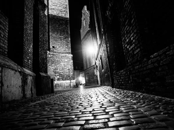 Illuminated cobbled street in old city by night — Stock Photo, Image