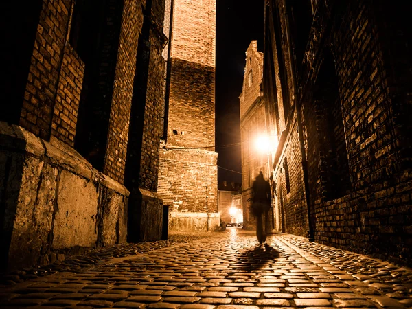 Illuminated cobbled street in old city by night — Stock Photo, Image