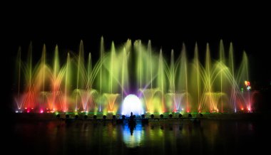 # Yılın kutlaması için dans eden renkli çeşme # # Karanlık gökyüzü arka planıyla #.