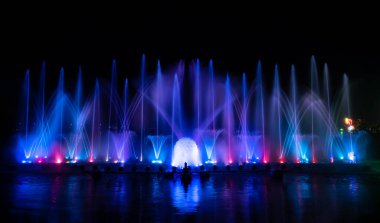 # Yılın kutlaması için dans eden renkli çeşme # # Karanlık gökyüzü arka planıyla #.