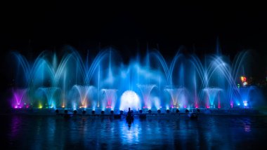 # Yılın kutlaması için dans eden renkli çeşme # # Karanlık gökyüzü arka planıyla #.