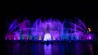 # Yılın kutlaması için dans eden renkli çeşme # # Karanlık gökyüzü arka planıyla #.