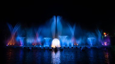 # Yılın kutlaması için dans eden renkli çeşme # # Karanlık gökyüzü arka planıyla #.