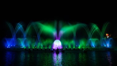 # Yılın kutlaması için dans eden renkli çeşme # # Karanlık gökyüzü arka planıyla #.