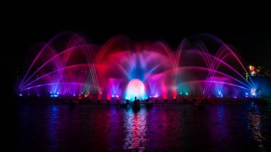 # Yılın kutlaması için dans eden renkli çeşme # # Karanlık gökyüzü arka planıyla #.