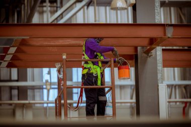 Portre mühendisi teftiş altında ve inşaat sürecini kontrol ediyor ve tren istasyonunda çalışmalarını kontrol ediyor. İş yerinde güvenlik üniforması ve güvenlik kaskı takan mühendis.