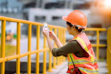 Atık su arıtma havuzu endüstrisini kontrol altında tutan işçiler, su destek endüstrisini kontrol etmek için, virüs ve kirliliği korumak için maske takıyorlar..