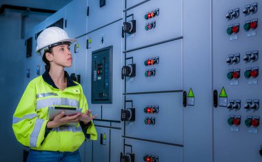 Mühendis, Ana Dağıtım Tahta Fabrikası 'nda çalışan voltaj aralığını kontrol etmek için elektrik santraliyle çalışıyor..