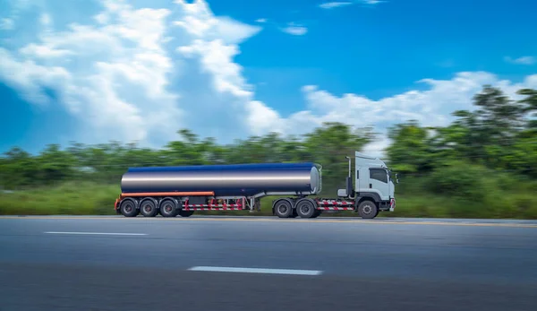 Gasoline tanker with fuel tanker truck shipping speed on high way road to delivery logistic business with mountain and sun sky background.