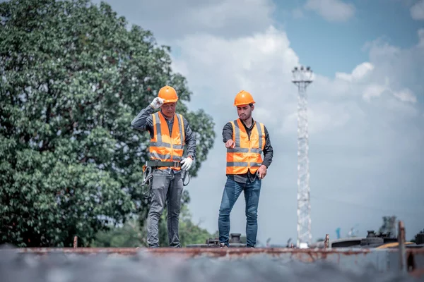 Mühendis teftiş altında ve inşaat sürecinde demiryolu şalterini kontrol ediyor ve tren istasyonundaki işi kontrol ediyor. İş yerinde güvenlik üniforması ve güvenlik kaskı takan bir mühendis..