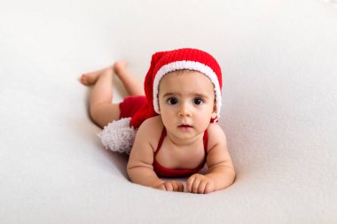 Yılbaşı geyik kostümlü şirin bir bebek. Beyaz arka planda mutlu bir bebek. Yeni doğan bebeğin yakın plan portresi. Bebek eşyaları paketleme şablonu. Çocuk odası. Tıbbi ve sağlıklı bir kavram. Noel zamanı. Yeni Yıl.