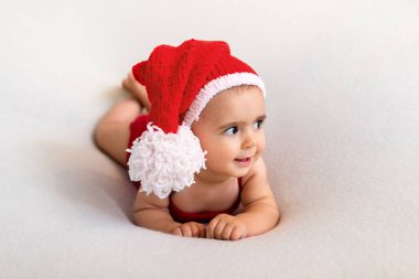 Yılbaşı geyik kostümlü şirin bir bebek. Beyaz arka planda mutlu bir bebek. Yeni doğan bebeğin yakın plan portresi. Bebek eşyaları paketleme şablonu. Çocuk odası. Tıbbi ve sağlıklı bir kavram. Noel zamanı. Yeni Yıl.