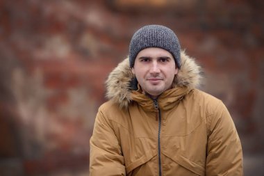 Şapkalı bir adamın kış portresi. Noel zamanı. Kar yağışı, soğuk. Mutlu yıllar. Kış tatilleri karlı ormanda