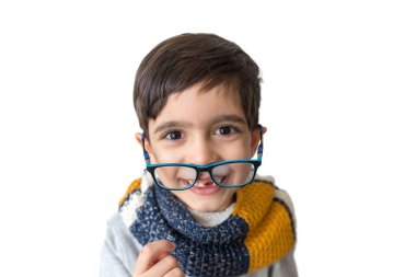 Beyaz arka planda eşarplı gözlüklü yakışıklı çocuk. Aile kavramı. Küçük çocuk. Dişsiz gülümseyen çocuk. Kış zamanı, Noel.