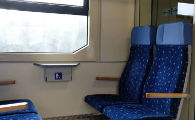 Tren koltukları ve pencereden manzara. Modern bir trende rahat sandalyeler, penceresinden güzel manzaralı. Avrupa 'da uzun ve kısa mesafeler için trenin içi boş.