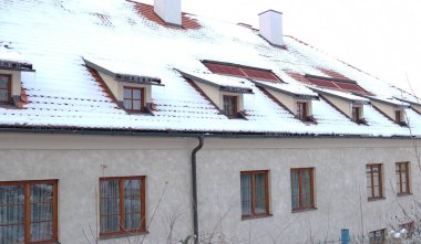 Gable çatısı olan dairelerin ve kışın karla kaplı yatakhanelerin dışında. Kışın şehir manzarası. Karda kiremitli çatı. Çek Cumhuriyeti 'nde tipik Avrupa evleri.