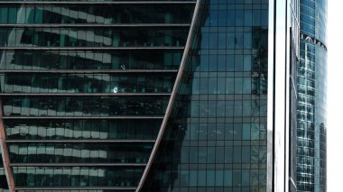Architectural detail of a skyscraper made of glass. Modern Architecture. Real estate, residential apartments and offices. Facade texture of a glass mirrored.
