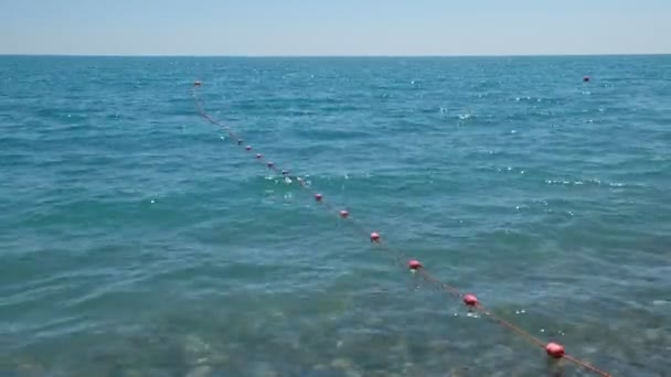 为安全起见 蓝色海水和红色浮标在波浪中漂浮 海浪在海滩上翻滚 冲破了漂浮的浮标 黑海假日 俄罗斯索契 — 图库视频影像