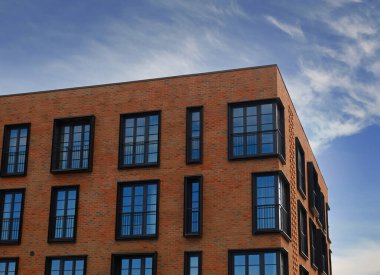 Modern tuğladan ev eşyalarının dış görünüşü. Bir gökdelenin mimari ayrıntıları, pencerelere yakın çekim. Gayrimenkul, apartman daireleri ve ofisler. Yaşayan daireler ya da ofis mimarisi.