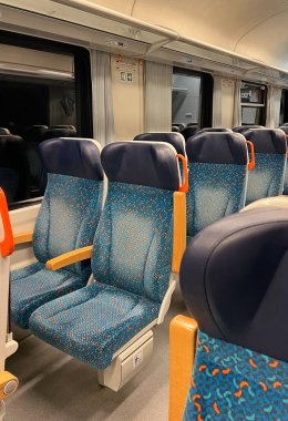 Boş banliyö tren vagonu mavi desenli koltuklar ve turuncu saplar, sığ alan derinliği, akşam işe gidiş gelişi.. 