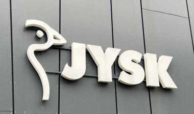 Tallinn, Estonya 'daki karanlık cephe üzerine minimalist JYSK amblemi - 24 Kasım 2025. JYSK, yatak, mobilya ve iç dekorasyon da dahil olmak üzere ev eşyaları konusunda uzmanlaşmış bir Danimarka perakende zinciri.. 