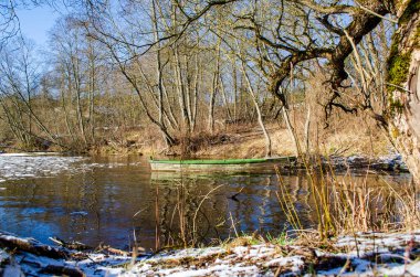 Mavi nehir manzarası ve eski ahşap tekne