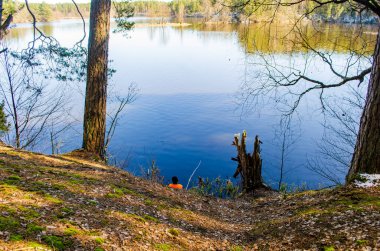 Elinde oltayla gölde olta atan bir balıkçı.