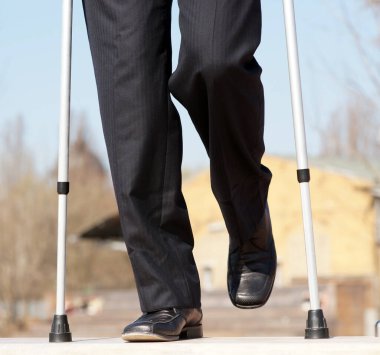 İşadamı ameliyattan sonra parkta çömelmiş oturuyor. 