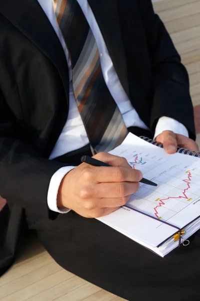 İşadamı şirket verilerini değerlendirir ve grafikleri ve değerleri kontrol eder