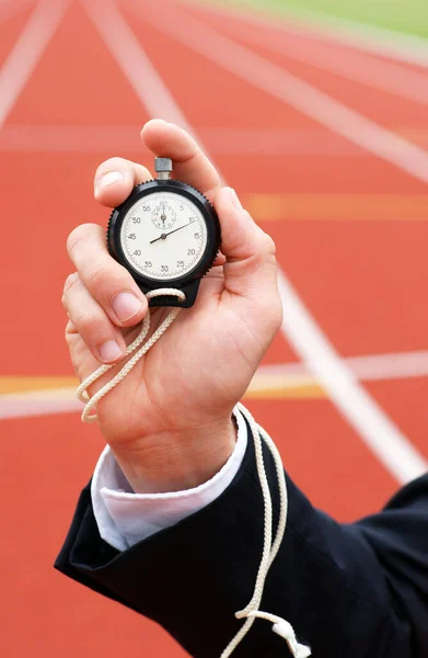 Die Zeit läuft - Geschäftsmann im Stadion hält Stoppuhr in der Hand - Nahaufnahme — Stockfoto