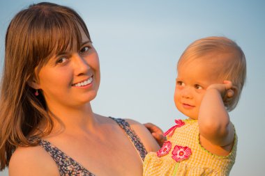 Anne ve kızı mavi gökyüzü karşı.